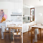 Cocina blanca con comedor, sillas y mesa de madera, armarios de madera clara y ventana con palmeras