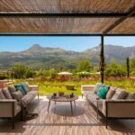 Überdachte Terrasse mit Pergola aus Schilfrohr, Sofas und Couchtisch vor der Serra de Tramuntana