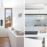 Cocina blanca con isla y ventana a palmeras, junto a detalle de fregadero y frontal de cristal