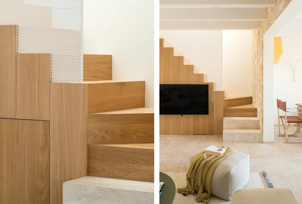 Treppe aus hellem Holz mit weißem perforiertem Paneel und Wohnzimmer mit Steinboden und integriertem Fernseher