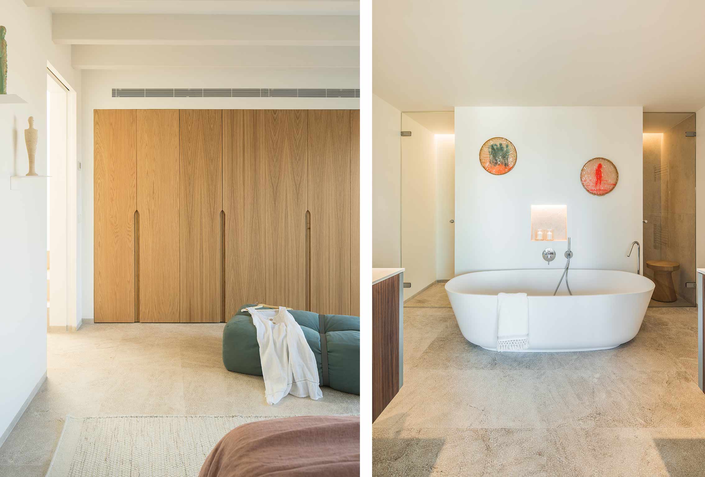 Heller Holzschrank im Schlafzimmer und weiße ovale Badewanne mit Glasdusche im Hintergrund