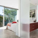 Dormitorio abierto al baño con mueble de madera oscura, bañera exenta y vistas a la montaña
