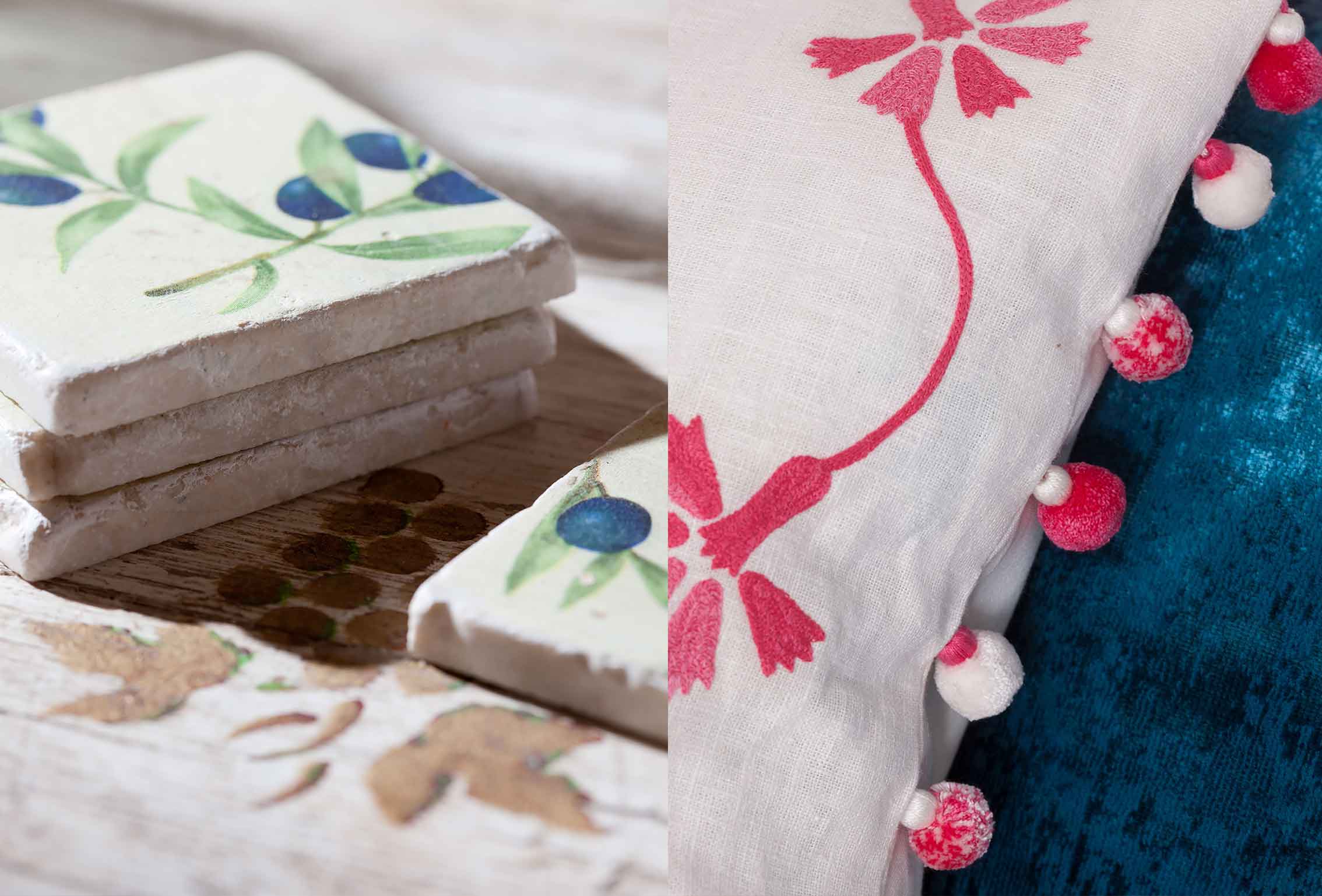 Detalles decorativos: losetas apiladas con olivo pintado y cojín blanco con pompones rosas sobre terciopelo azul