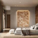 Bedroom with an upholstered bed, a large backlit painting in copper tones, wooden floor and a large window onto the garden