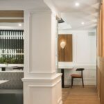 White pillar with mouldings, wooden parquet and a slatted niche with a heart sculpture at the back