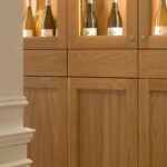 Detail of a light timber cabinet with glass display cases and wine bottles