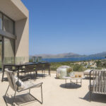 Terrasse der Villa LF91CG01 mit Essbereich und Außensofas sowie Blick auf Bucht und Berge