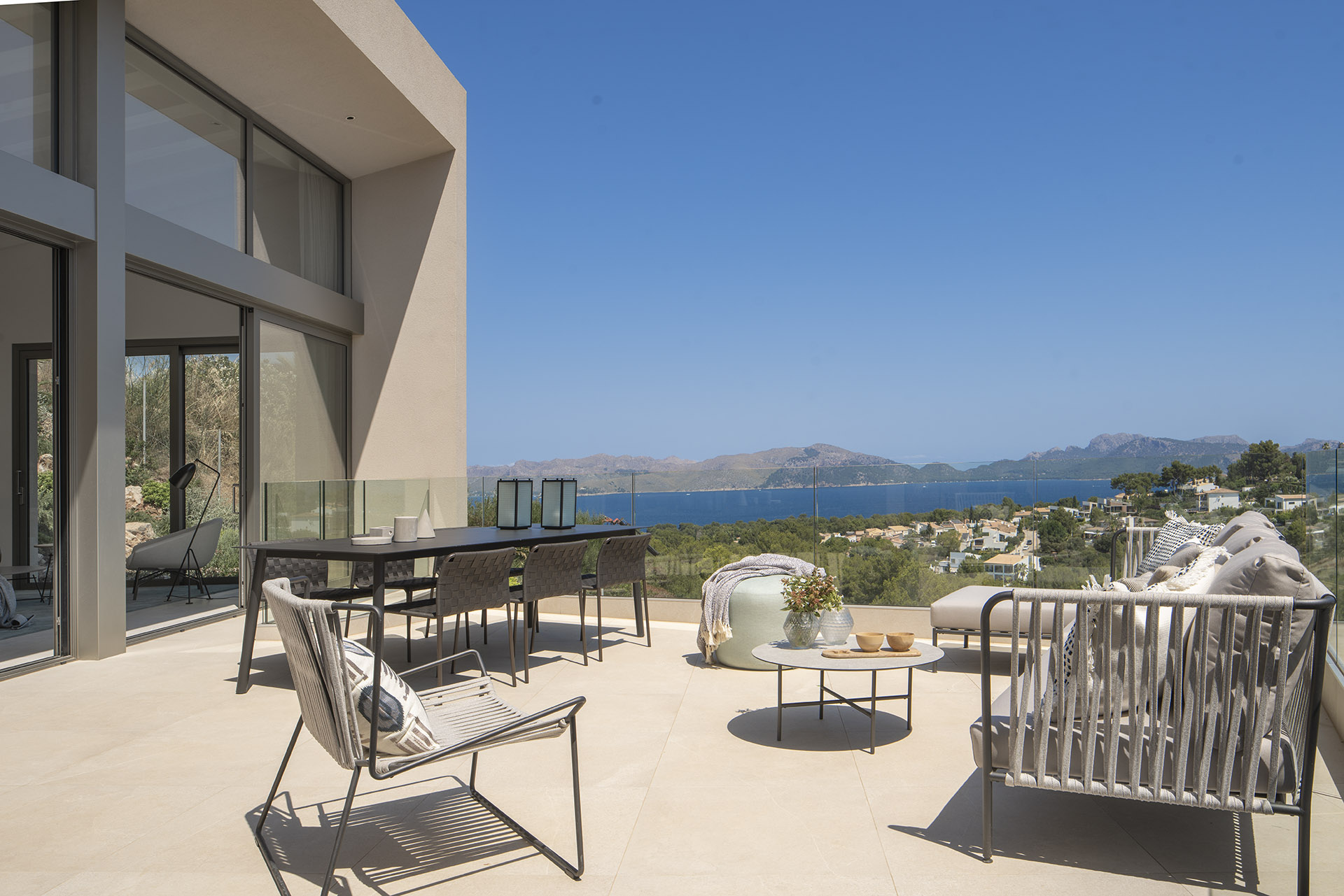 Terrasse der Villa LF91CG01 mit Essbereich und Außensofas sowie Blick auf Bucht und Berge