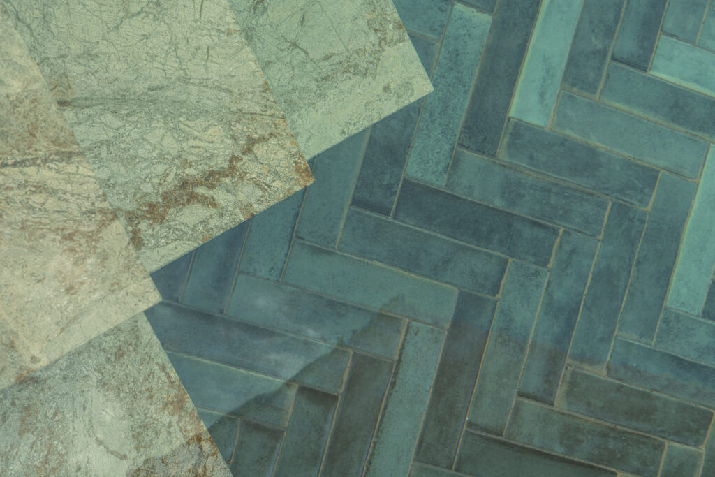 Detalle de piezas de mármol verdoso junto a azulejos turquesa dispuestos en espiga