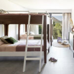 Kinderzimmer mit Etagenbetten in Nussbaum und Weiß, grauem Boden und Blick auf die Berge