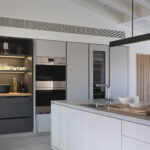 Tall grey units with steel ovens, wine cooler and an illuminated coffee corner