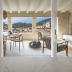 Covered summer dining area with a round table and views of the rooftops and the mountain