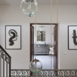 Landing with abstract black and white paintings, glass lamps and dark wooden doors