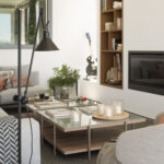 Living room detail with floor lamp, coffee tables with candles, built-in shelving and fireplace