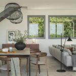 Dining room with wooden table, upholstered chairs, black wire pendant lights and terracotta sideboard