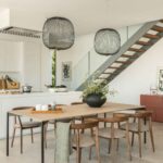 Dining area with wooden chairs next to the kitchen and the staircase with timber treads