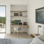 Bedroom with built-in work corner, wooden shelves, sea-facing window and access to the terrace