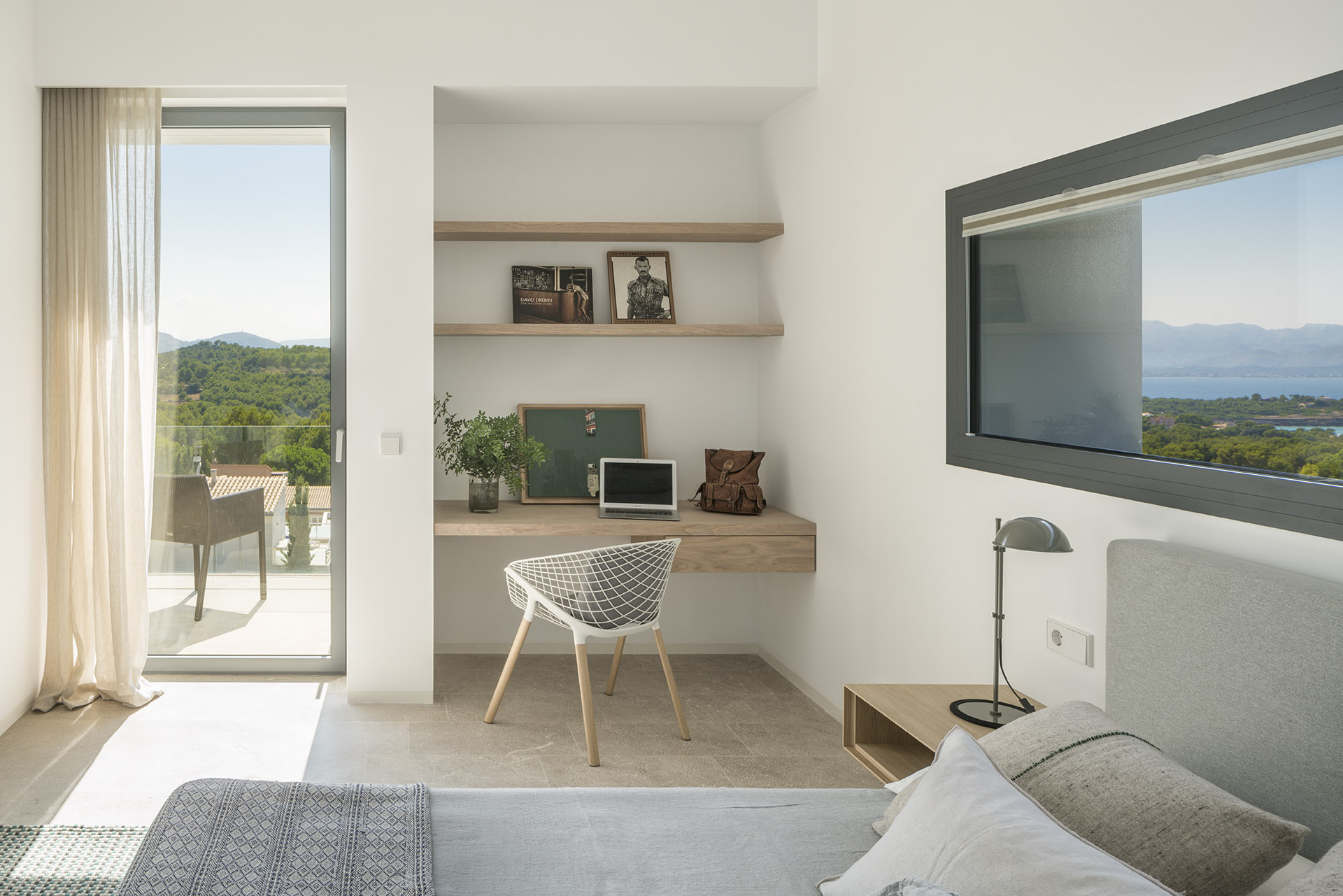 Bedroom with built-in work corner, wooden shelves, sea-facing window and access to the terrace