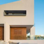 Façade detail with timber cladding, overhang, elongated window and stone steps