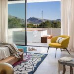 Dormitorio con puerta corredera de cristal a una terraza con jacuzzi y vistas a la montaña