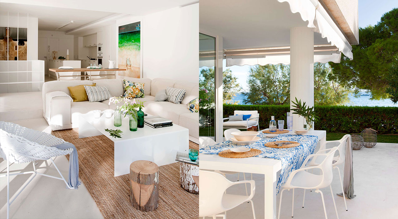 Randemar: salón blanco con alfombra de yute y terraza con mesa de mantel azul junto al mar