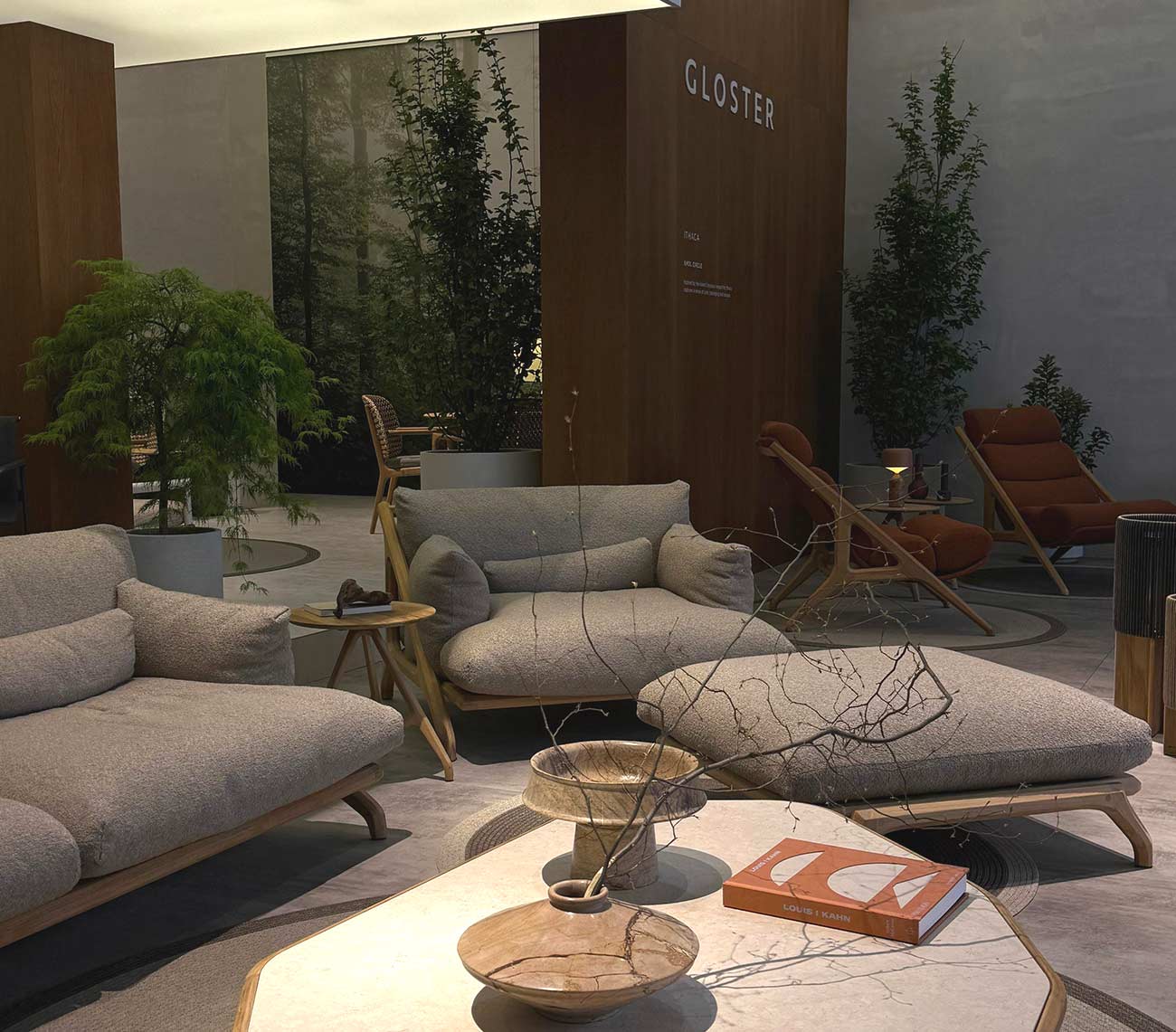 Stand von Gloster mit grauen Sofas, terrakottafarbenen Sesseln, Pflanzen und Steintisch