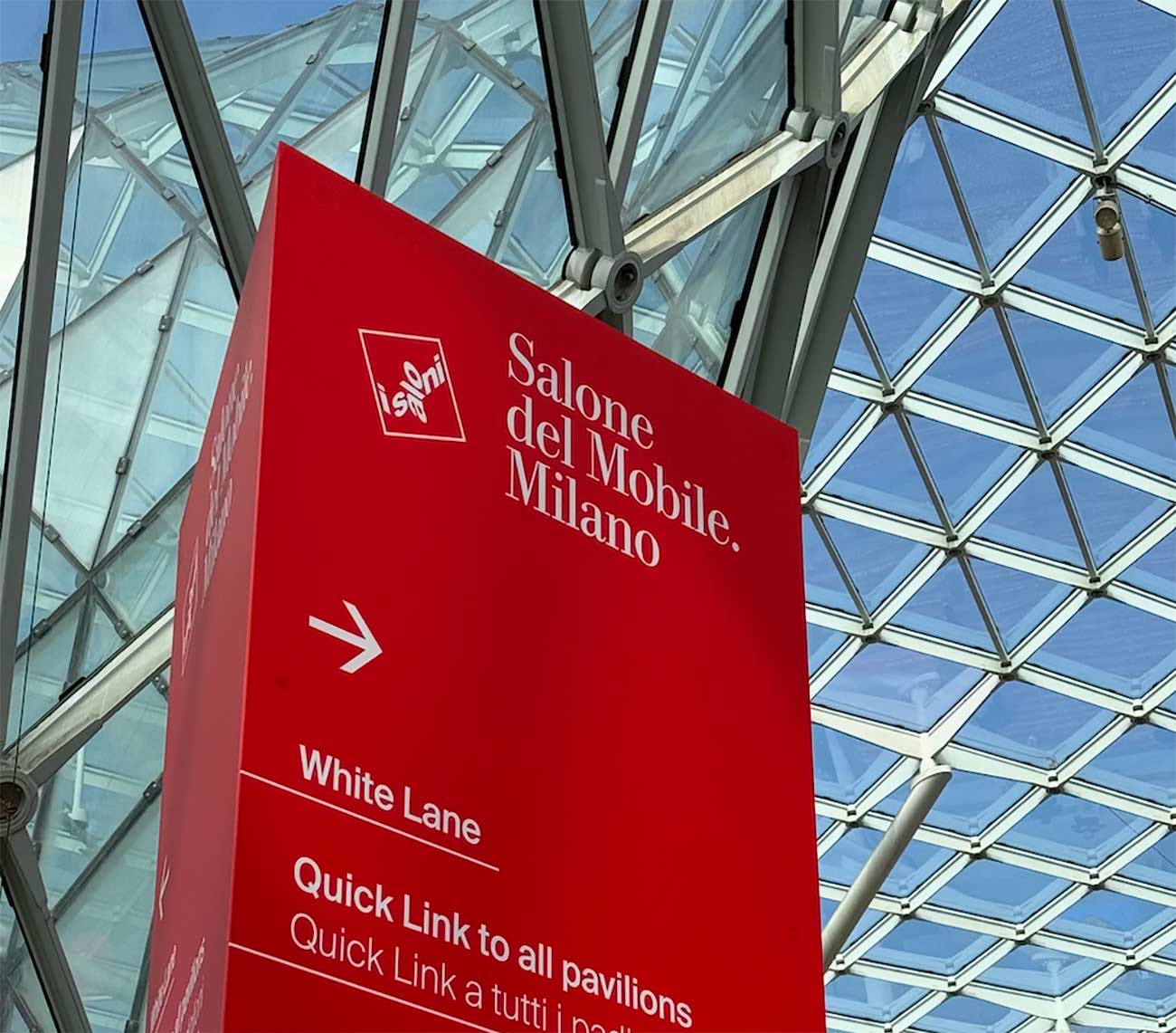 Rotes Plakat der Salone del Mobile in Mailand unter einem Dach aus Glas und Stahl