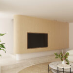 Salón con pared curva de roble y televisor empotrado, sofá curvo blanco, mesas de mármol y una planta