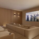Render of the Can Gat home cinema with a panoramic screen and large sofas