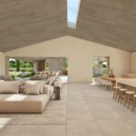 Render of the living room and kitchen with a long island and stools, opening onto the porch and garden